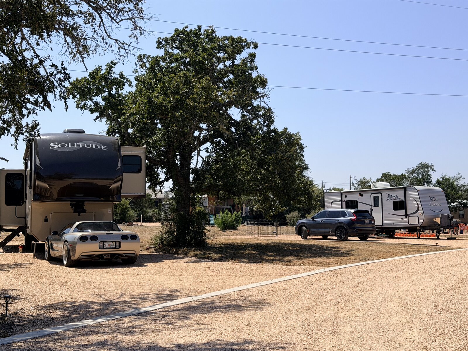 A fifth wheel parked on an oversized site under a mature oak at Seven Lakes RV Resort
