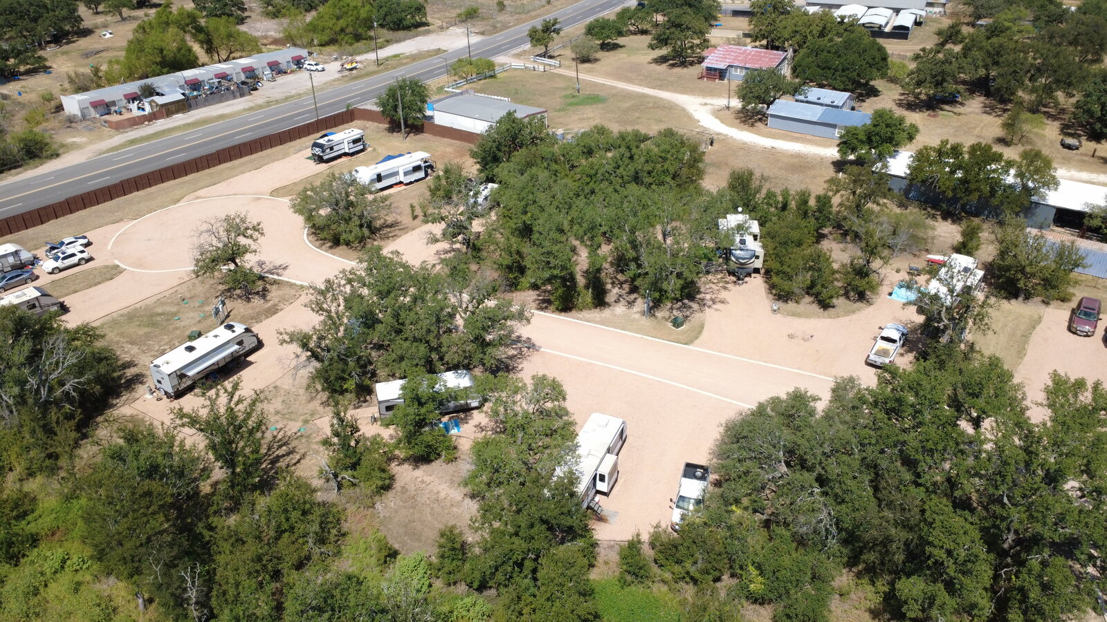 Aerial view of Seven Lakes RV Resort showing wide, well-spaced sites and the fenced perimeter