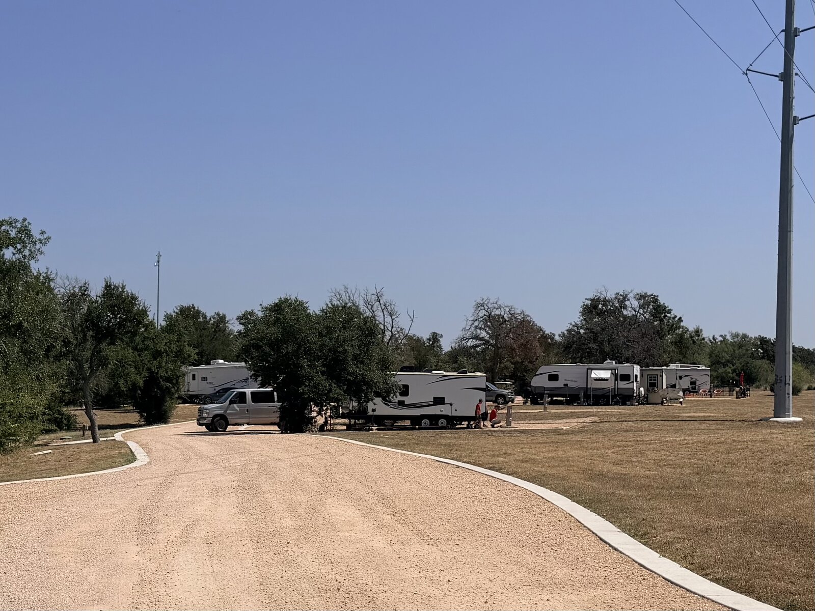 Wide interior road at Seven Lakes RV Resort lined with well-spaced RV sites
